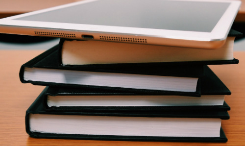 ipad on a stack of books